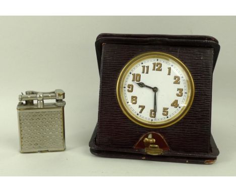 A red morocco cased bedside clock, circular enamel dial bearing Arabic numerals, Sphinx movement, and a plated Dunhill Unique