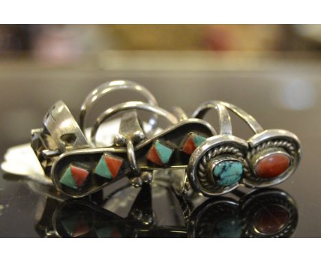 A native American white coloured metal ring set with turquoise and coloured stones; a silver dress ring set with clear amethy