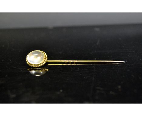 A 19th century gold coloured metal and moonstone stick pin