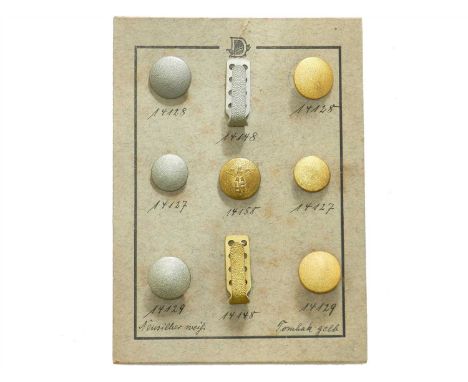 A German Third Reich salesman sample board comprising three silver buttons and three gold tombak buttons, one further button 