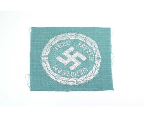 A German Security Police (Schuma) Officers Arm insignia, machine woven in silver wire over blue-green rayon cloth centering d