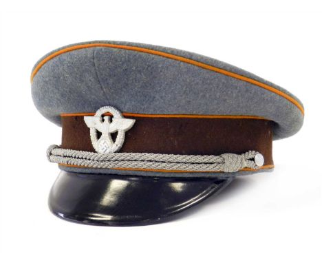 A German Third Reich Feldgendarmerie Officer’s visor cap (Rural Police) constructed of field grey wool with a brown centreban