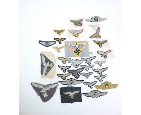 Twenty assorted German Third Reich Luftwaffe visor cap eagles together with three Officer and one General embroidered wreaths