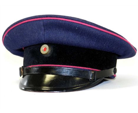 A German Third Reich Fire Police NCO/EM visor cap with carmine and red piping and a leather chin strap (lacking fire badge) t