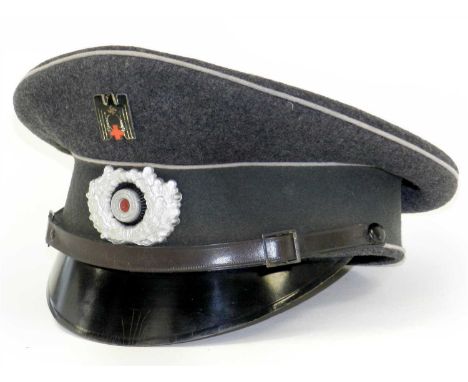 A German Third Reich DRK visor cap ( Deutsche Rote Kreuz - German Red Cross) constructed of dark grey wool with a grey centre