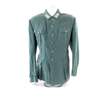 A German Third Reich Schutzpolizei NCO’s field blouse constructed of police green wool with featuring four pockets with field