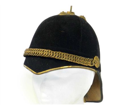 A late 19th/early 20th century black cloth covered military helmet with brass chin-scales, rosettes and mounts, interior with