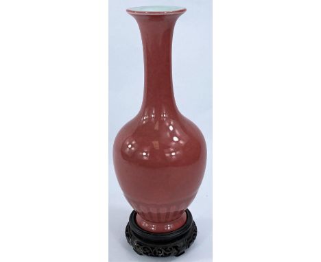 A Chinese pink enamelled porcelain vase of baluster form, 6 character mark to base, 20cm (Good condition) and hardwood stand