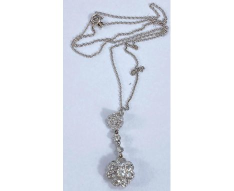 A white metal pendant set 16 diamonds in the form of a large and a small flowerhead cluster, on unmarked white metal chain.&n