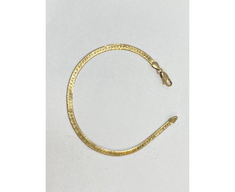 A yellow metal flattened curb chain bracelet stamped 14K, 3.8gm 