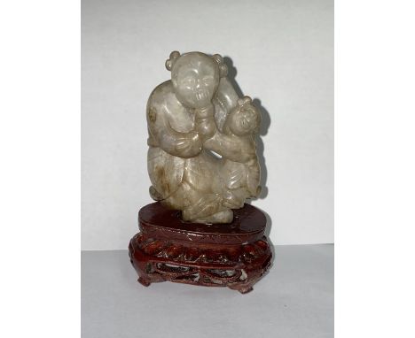 A Chinese carved jade figure of mother and child, 64mm, with stand (good condition) 