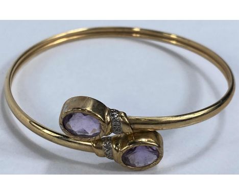 A 9 carat hallmarked gold slave bangle, each terminal set with an oval amethyst 