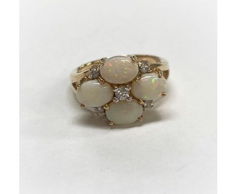 A 9 carat hall marked gold ring set with 4 opal coloured stones and 5 diamond simulants 4.5cm 