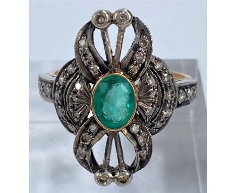 A vintage yellow metal ring set oval emerald surrounded by 38 diamonds in white gold, shank stamped '750', 4.2 gm, size O 