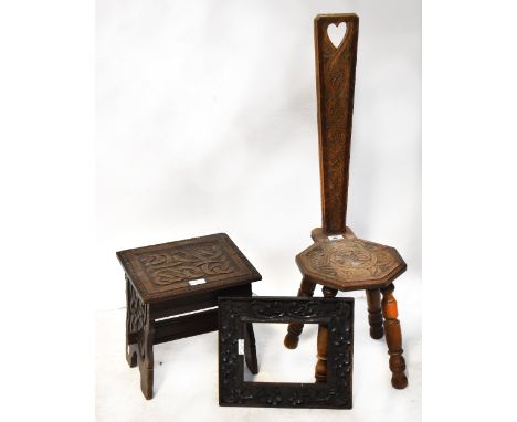 A carved oak hall chair, the back with heart-shaped motif, raised on turned supports, a small carved stool with Celtic knot d