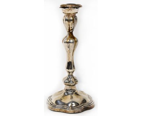 A George V hallmarked silver candlestick of lobed inverted baluster form, raised on a stepped shaped base, maker's mark indis