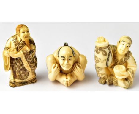 Three Japanese netsuke comprising a contortionist, a seated man holding a sack and bowl, and a standing man holding out a bow