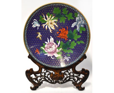 A Chinese cloisonné charger depicting a bird flying amongst chrysanthemums on dark blue ground within a light blue of cloud t