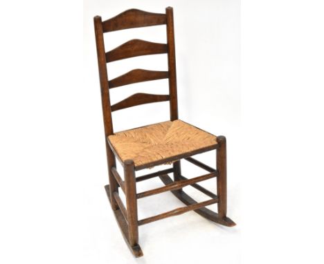 A 19th century rush seated country made ladder back rocking chair.