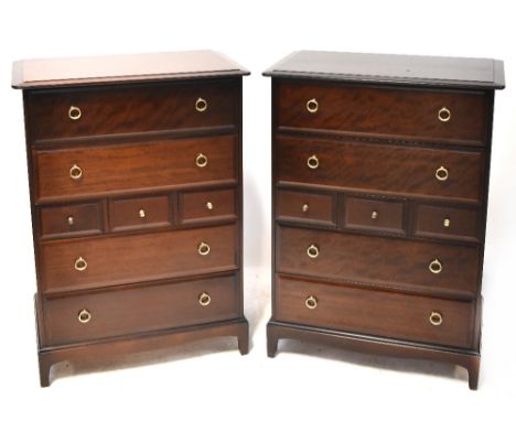 A pair of Stag Minstrel dark stained chestS of drawers, each with four long and three short drawers, on bracket feet and ring