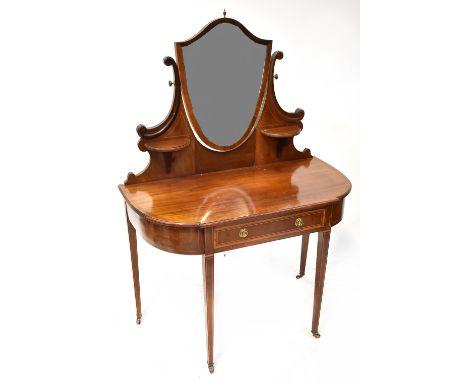 An Edwardian inlaid mahogany dressing table with shield-shaped mirror to the top, flanked by a pair of demi-lune shelves, on 