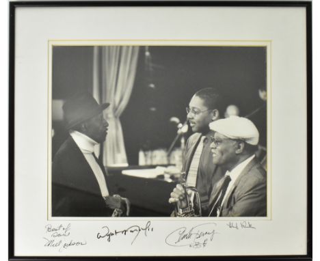 JAZZ MUSICIANS; a black and white photograph of three Jazz musicians in conversation, bearing four signatures to the mount in