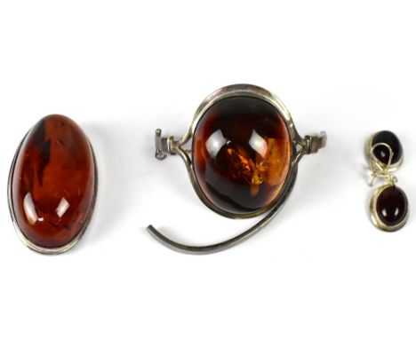 A hallmarked silver bangle set with large cabochon amber (af), a similar oval amber brooch, length 5.5cm, and pair of drop ea