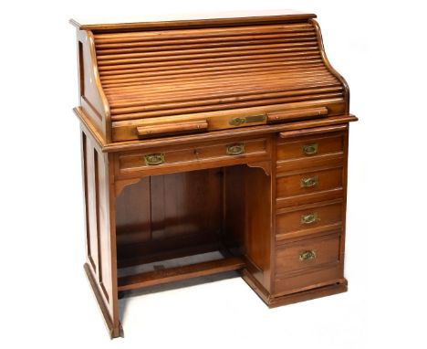 An early 20th century walnut roll top desk with fitted interior, gilt tooled leather writing surface above single long drawer