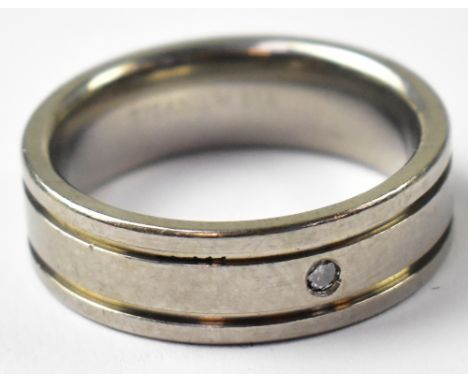 A modern two-tone flat profile diamond titanium wedding band ring, with single gypsy set diamond, with two groove outer bands