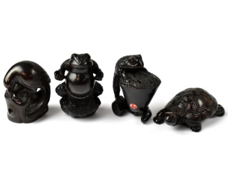 Four Japanese carved wooden netsuke comprising a tortoise, a frog wearing a loin cloth, a froglet sitting on a flower and a b