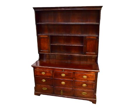 An early 19th century oak mule chest, lift-up top above six faux doors, three drawers to the base with carved leaf pillars to