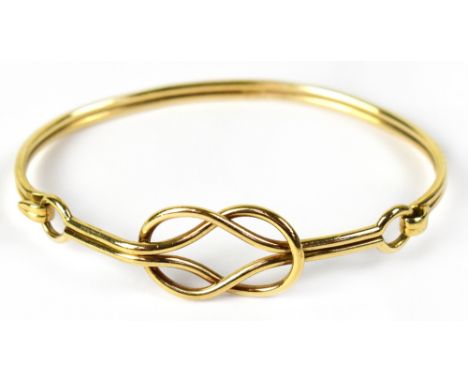 A 9ct gold bangle in the form of a Celtic knot with loop clasp, stamped 375, approx 15.7g.