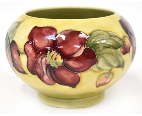 MOORCROFT; a mid-20th century flower planter/bowl with 'Clematis' pattern on an egg yolk yellow wash ground, raised on short 