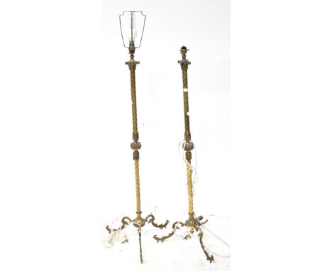 A pair of brass barleytwist standard lamps with scrolling acanthus leaf decoration, raised on three outswept supports, height
