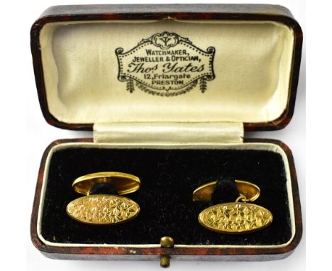 A pair of gentlemen's hallmarked 9ct gold oval cufflinks, one with engine turned floral pattern, the other blank, united by s