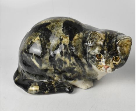 A Winstanley ceramic crouching cat with glass eyes, signed to base and numbered 5, height 19cm, length 31cm.