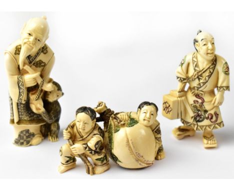 Three Japanese netsuke, one in the form of a man with a monkey at his feet, a man holding a box and pair of seated children h
