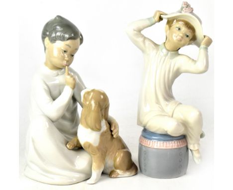 A Lladró figure of a boy in nightshirt with a spaniel on his knee, no.4522, and a Lladró figure of a girl seated on a pouffe,