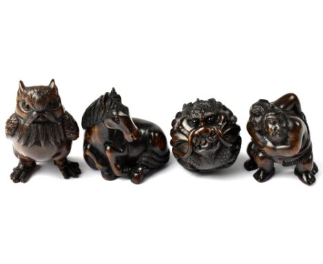Four Japanese carved wooden netsuke comprising an owl, a horse lying down, two figures wrestling and a dragon ball, all signe