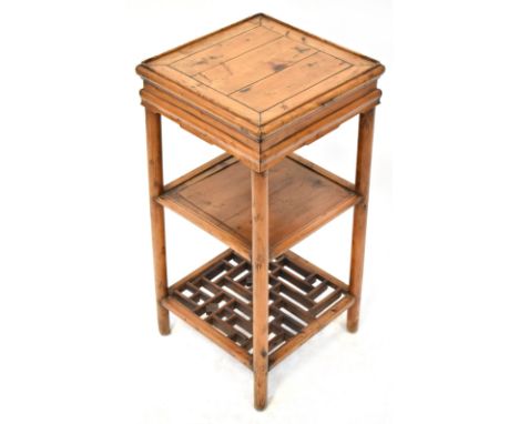 A reproduction Oriental hardwood square section jardinière stand with central shelf and lower lattice work decoration with ca