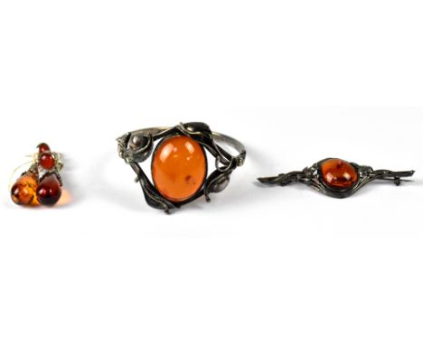 A silver bangle set with oval cabochon amber in Art Nouveau style mount, a similar bar brooch and a pair of drop pendant earr
