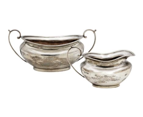 A George V silver cream jug and sugar bowl by Barker Brothers. With gadrooned rims, Chester 1924, width of sugar bowl 18cm, 1