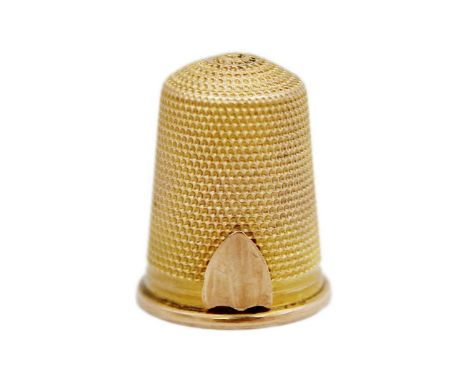 A gold thimble, testing as 14k, with fine dimpling and vacant shield cartouche. Length 21mm, 5.1g.