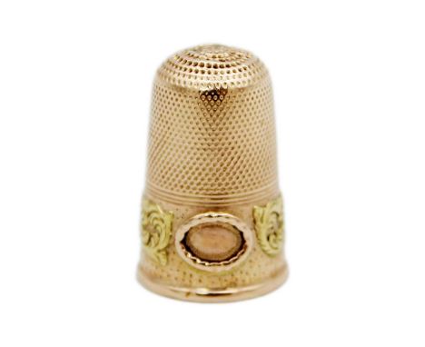 A 19th century yellow and rose gold thimble. Applied with a yellow gold foliate scroll band, length 25mm, 4.3g.