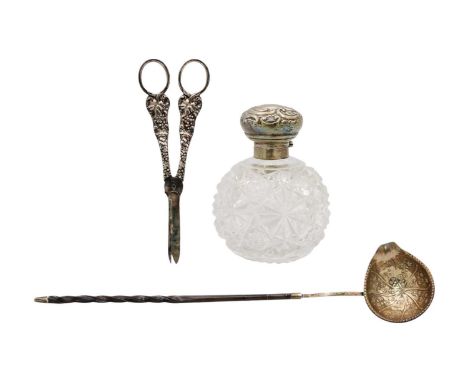 A silver topped cut-glass scent bottle, toddy ladle and pair of plated grape scissors. The scent bottle hallmarked London 190