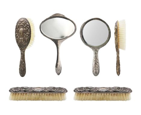 A silver five-piece dressing table set. In Victorian style embossed with foliate scrolls, Birmingham 1958; together with a si