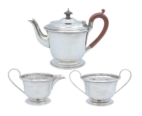 A George VI silver three-piece tea set by John Rose. Of circular footed form, the teapot with bakelite handle and finial, Bir