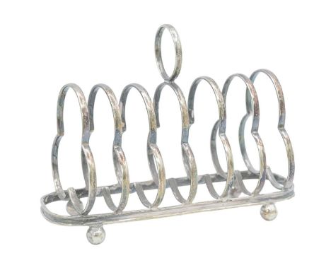 An Edwardian silver six-section toast rack by James Deakin & Sons. The wire divisions of tri-lobed form, raised on ball feet,