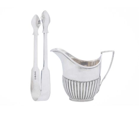 An Edwardian silver cream jug, and a pair of George IV sugar tongs. The jug of fluted form, by William Hatton &amp; Sons Ltd,