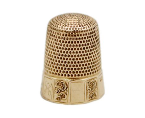 A USA 14k rose gold thimble by Simon Bros. The base with faceted panels with alternating foliate scroll engraved design, engr